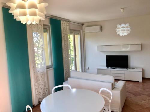 a living room with a couch and a table and a tv at Nevegal - Piccolo gioiello vicino al centro in Visome