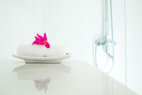 a white towel with a flower on top of it at Villa Yrondi in Bora Bora