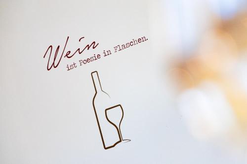 a label for a bottle of wine with a glass at Das Blaufränkisch Weinhotel & Restaurant in Girm