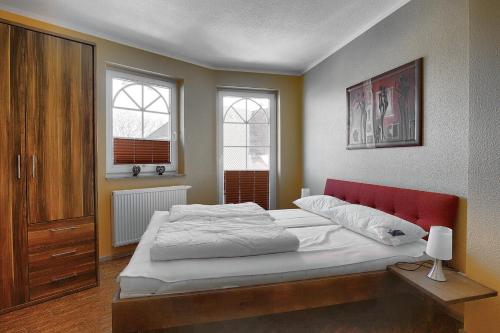 ツィングストにあるVilla Sonnenuhr, FW 8のベッドルーム1室(赤いヘッドボード付きの大型ベッド1台付)