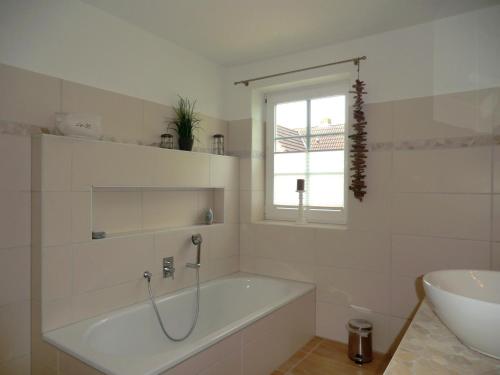 a white bathroom with a tub and a sink at Nordwind in Oevenum