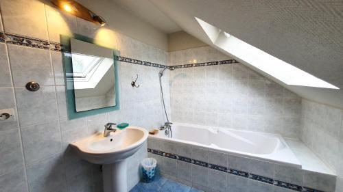 a bathroom with a sink and a bath tub at Maison charmante à Plourhan avec jardin et terrasse in Plourhan