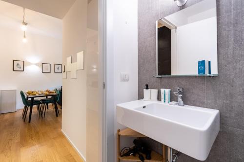 bagno con lavandino bianco e tavolo di Sweet Inn - Cozy Duomo a Milano