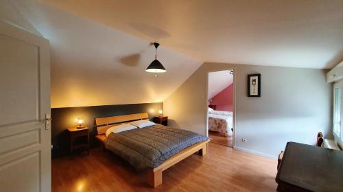 a bedroom with a bed and two tables and a lamp at Maison charmante à Plourhan avec jardin et terrasse in Plourhan