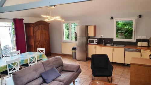 Il dispose d'une cuisine et d'un salon avec un canapé et une table. dans l'établissement Maison charmante à Plourhan avec jardin et terrasse, à Plourhan