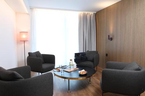a living room with chairs and a table in a room at Best Western Plus Ten Hotel in Upplands-Väsby