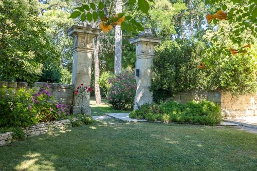 a garden with two stone pillars and flowers at Mas de Capelou in Avignon