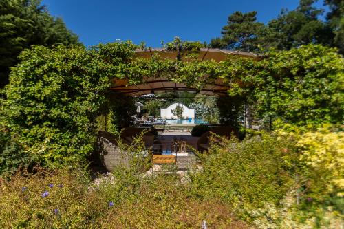 a garden with a pergola with a pool in the background at Mas de Capelou in Avignon