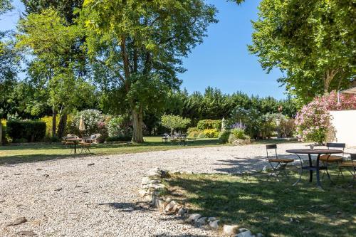 a picnic table and chairs in a park at Mas de Capelou in Avignon