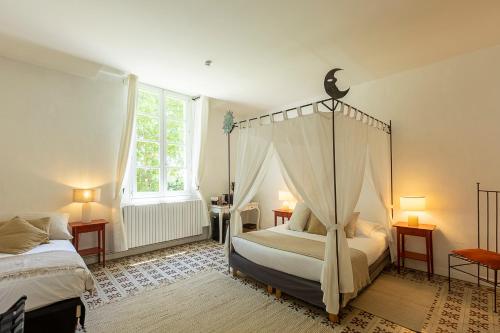 a bedroom with a canopy bed and a window at Mas de Capelou in Avignon