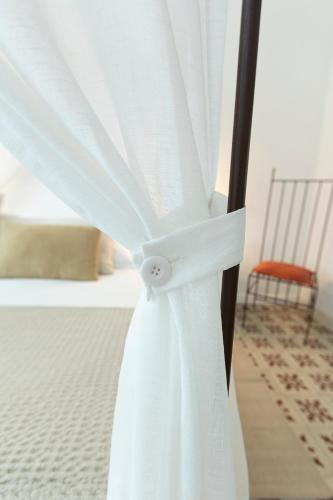 a close up of a white curtain on a bed at Mas de Capelou in Avignon