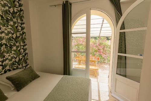 a bedroom with a bed and a door to a patio at Mas de Capelou in Avignon