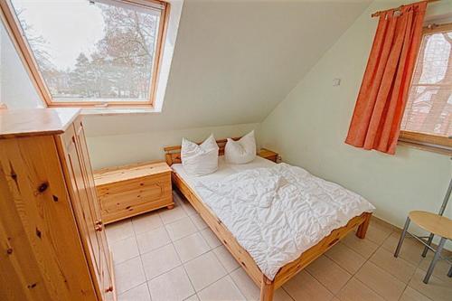 ein kleines Schlafzimmer mit einem Bett und einem Fenster in der Unterkunft Am Deich 09 in Zingst