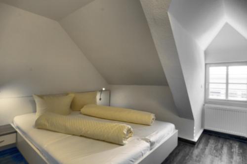 a bed in a room with a window at Altes Wasserwerk, FW 6 in Zingst