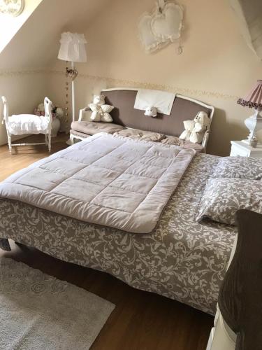 une chambre avec un grand lit dans une pièce dans l'établissement Les Chambres de Paule, à Thieulloy-lʼAbbaye