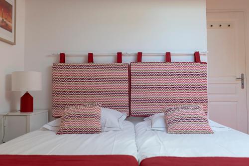 a bed with a red headboard and two pillows at Mas de Capelou in Avignon