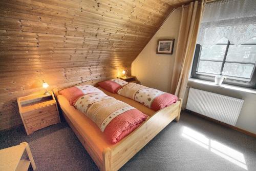 two beds in a room with a wooden wall at Kuhn in Zingst
