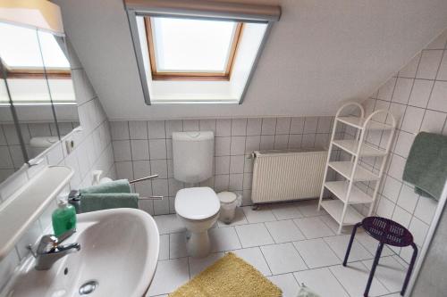 a bathroom with a sink and a toilet with a skylight at Kuhn in Zingst