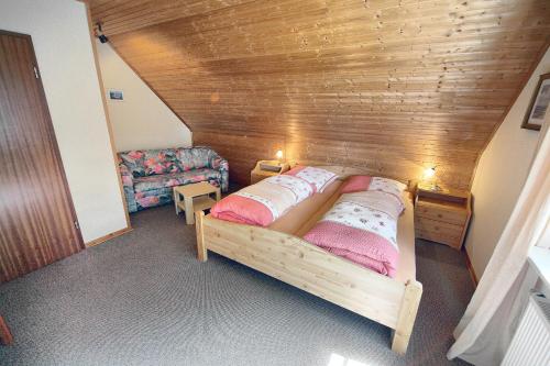 a bed in a room with a wooden wall at Kuhn in Zingst