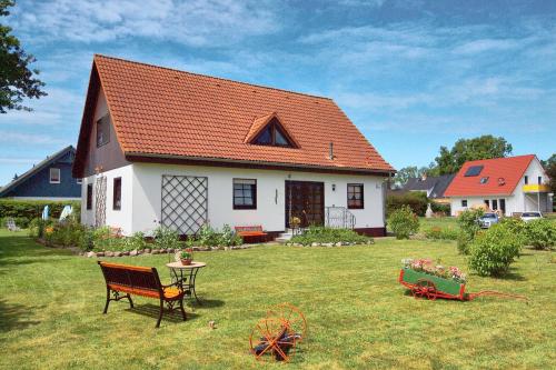 a white house with an orange roof in a yard at Kuhn in Zingst