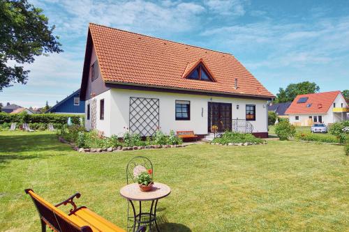 a white house with an orange roof on a yard at Kuhn in Zingst