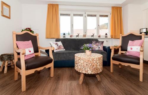 un soggiorno con divano, 2 sedie e tavolo di Baumgartenschneid a Bad Wiessee