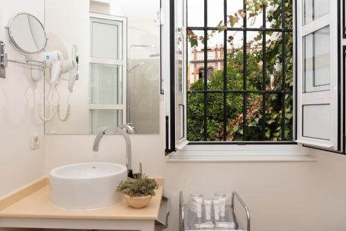 łazienka z umywalką i oknem w obiekcie Hotel Boutique Elvira Plaza w Sewilli