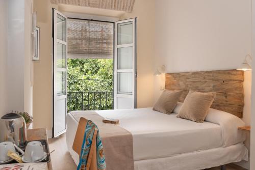 sypialnia z łóżkiem i dużym oknem w obiekcie Hotel Boutique Elvira Plaza w Sewilli