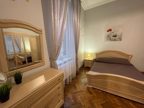 um quarto com uma cama e um espelho grande em 3 rooms apartments in the city centr em Lviv