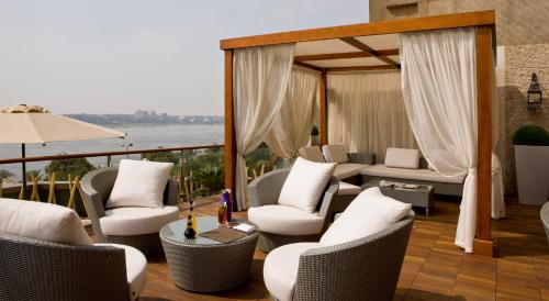 Holiday Inn Cairo Maadi, an IHG Hotel في القاهرة: شرفة مع كراسي وإطلالة على الماء