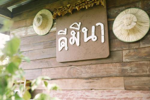 a sign on the side of a wooden wall at Phuruarounmai Organic Living Resort in Loei