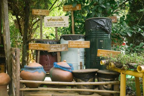 a display of pots and trash cans in a garden at Phuruarounmai Organic Living Resort in Loei
