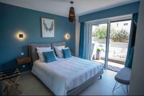 une chambre avec un grand lit aux murs bleus dans l'établissement Haut de villa de charme - 3 chambres 6pers, à Saint-Raphaël