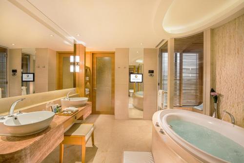 łazienka z 2 umywalkami i wanną w obiekcie Hotel Okura Macau w mieście Makau