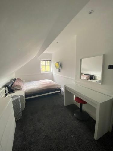 a bedroom with a bed and a desk with a mirror at Pristine 2 bedroom apartment with off street parking in Norwich