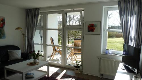 a living room with a sliding glass door with a patio at Wohnpark Sandkrug in Sandkrug