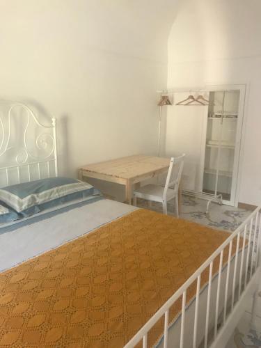 a bedroom with a bed and a table and a chair at IL MELOGRANO La Casa nel Vicoletto in Lanciano