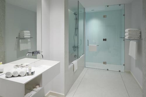 a white bathroom with a shower and a sink at Staybridge Suites Al Khobar, an IHG Hotel in Al Khobar