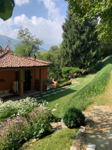 a house with a garden and a lawn with flowers at Il Mulino di Valeria in Canzo