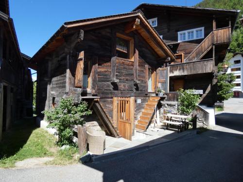 una baita di tronchi con portico e porta in legno di Ferienhaus Z‘ Gädi a Ernen