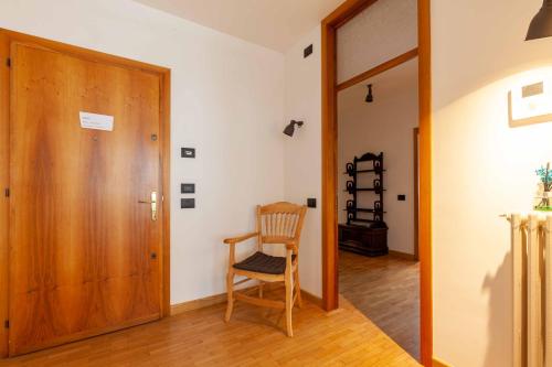 a room with a wooden door and a chair at Attico in Centro a Belluno - Marmolada in Belluno