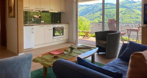 cocina y sala de estar con mesa y sillas en Ferienwohnung Traumblick en Schönau im Schwarzwald