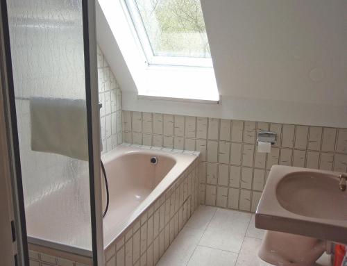 a bathroom with a bath tub and a sink at FeWo Gottorf in Ulsnis