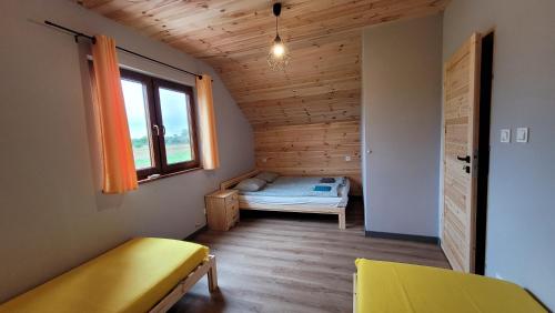 mały pokój z łóżkiem i oknem w obiekcie Wrzosowe Wzgórze Domek w Chęcinach
