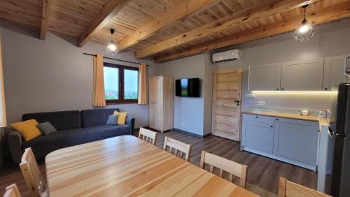 a living room and kitchen with a couch and a table at Wrzosowe Wzgórze Domek 3 sypialnie in Chęciny