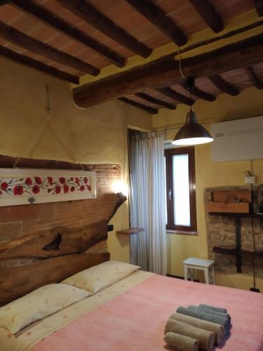 a bedroom with a large bed with a wooden headboard at Casa Giulia on Francigena in Gambassi Terme