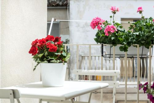 a white table with two potted flowers on it at Aurà - Guest House Iblea in Ragusa