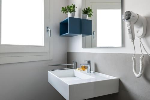 a bathroom with a white sink and a phone at Aurà - Guest House Iblea in Ragusa