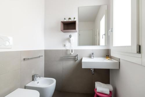 a bathroom with a sink and a toilet and a mirror at Aurà - Guest House Iblea in Ragusa
