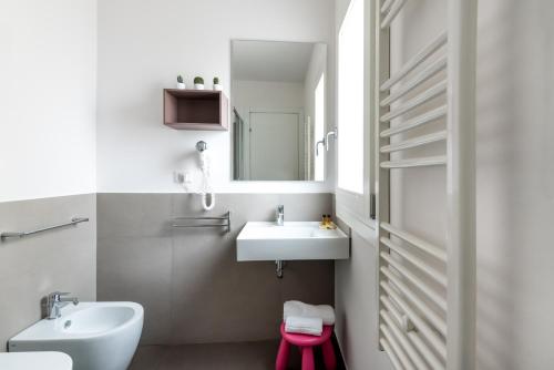 a white bathroom with a sink and a mirror at Aurà - Guest House Iblea in Ragusa
